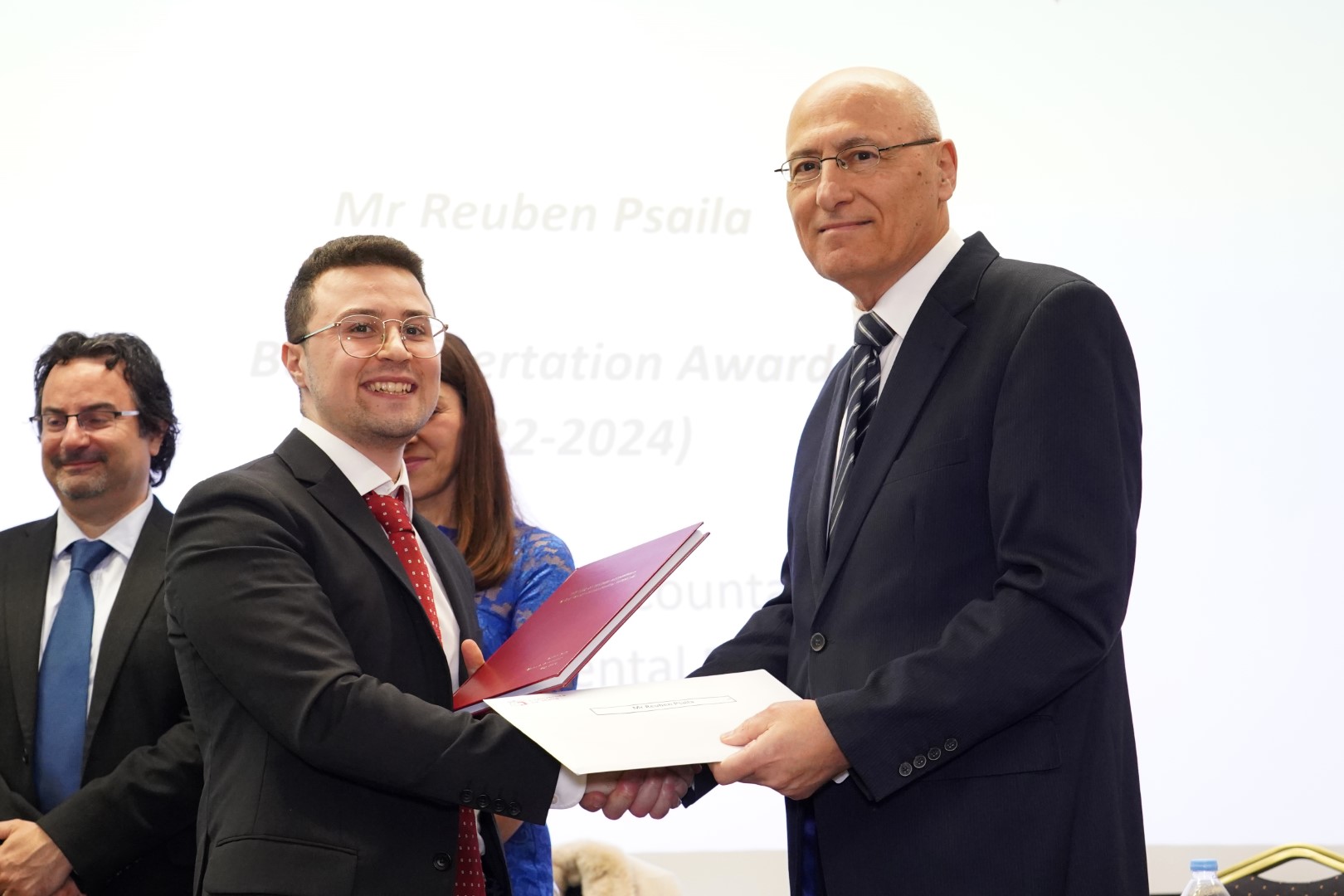 Mr Bonello presenting a prize and certificate to Mr Reuben Psaila Mr Bonello presenting a prize and certificate to Mr Reuben Psaila
